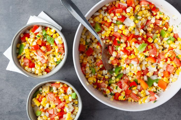 Full yield of Taste of Home Fresh Corn Salad in a large serving bowl, plus two single servings