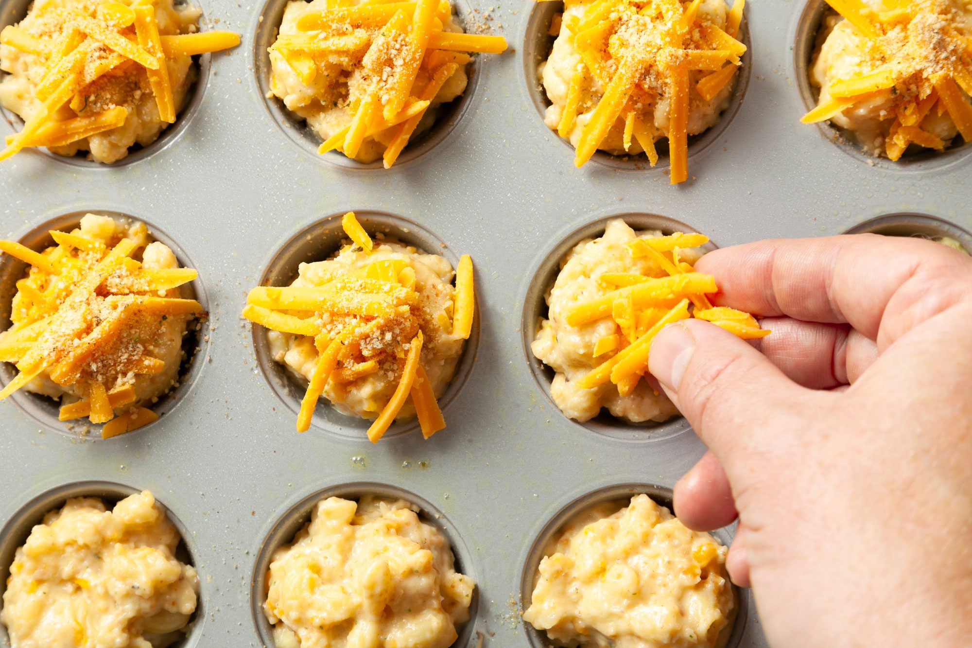 Overhead shot of sprinkle with remaining cheddar cheese and seasoned bread crumbs;