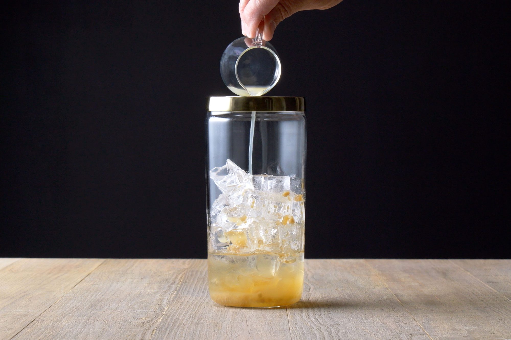 Adding the ice and light rum into shaker