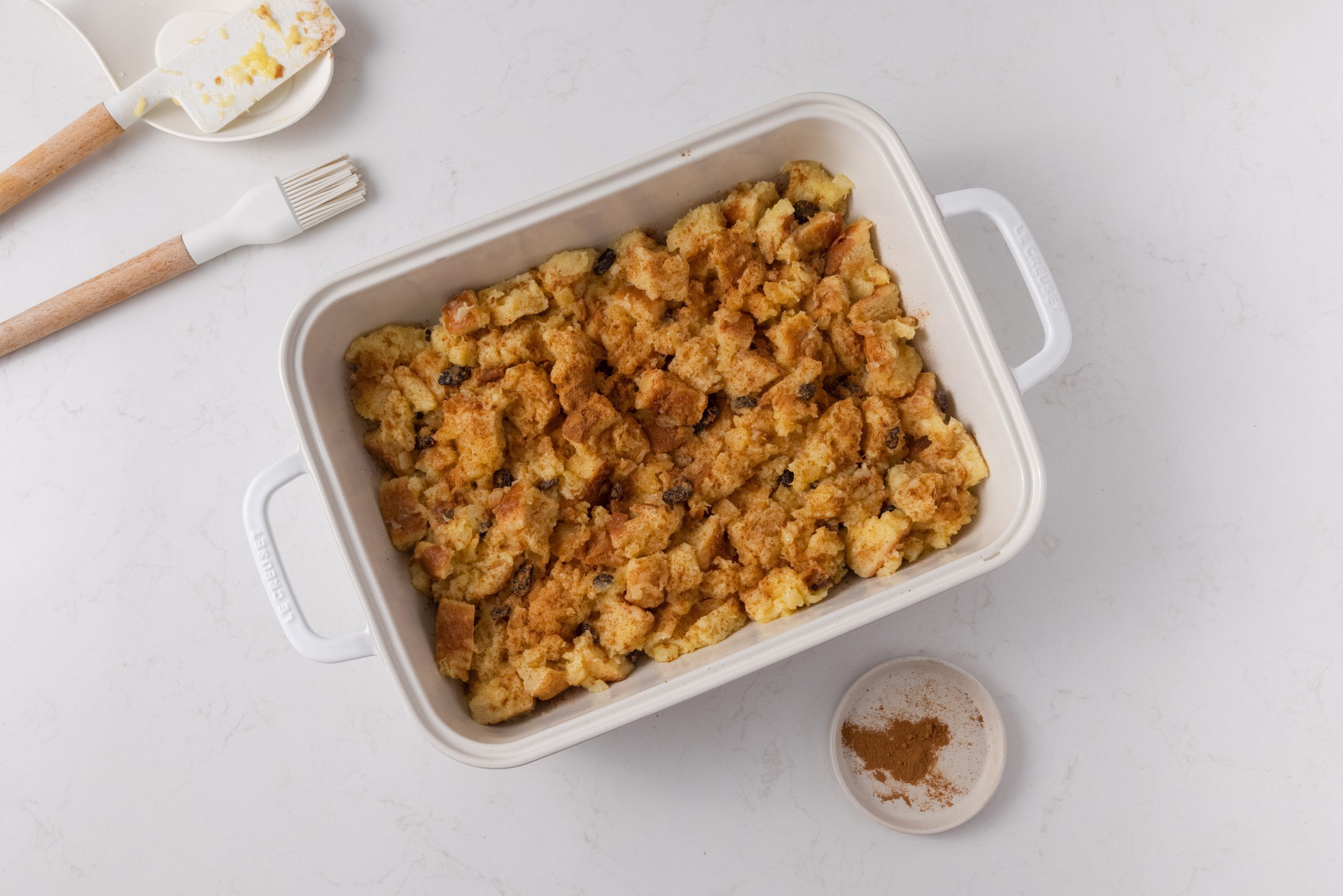 Pineapple bread pudding in greased baking dish ready to be baked.