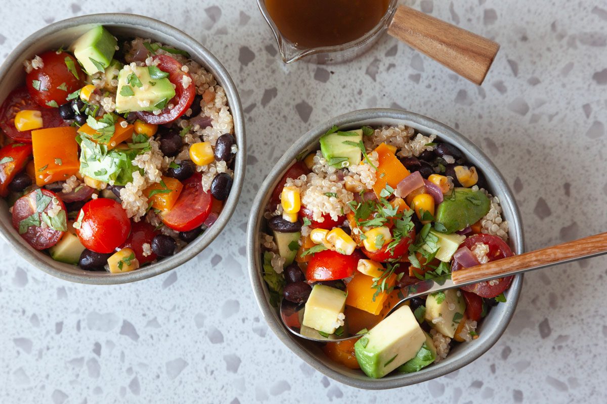 two single serings of Southwest quinoa salad with a small cruet for extra dressing