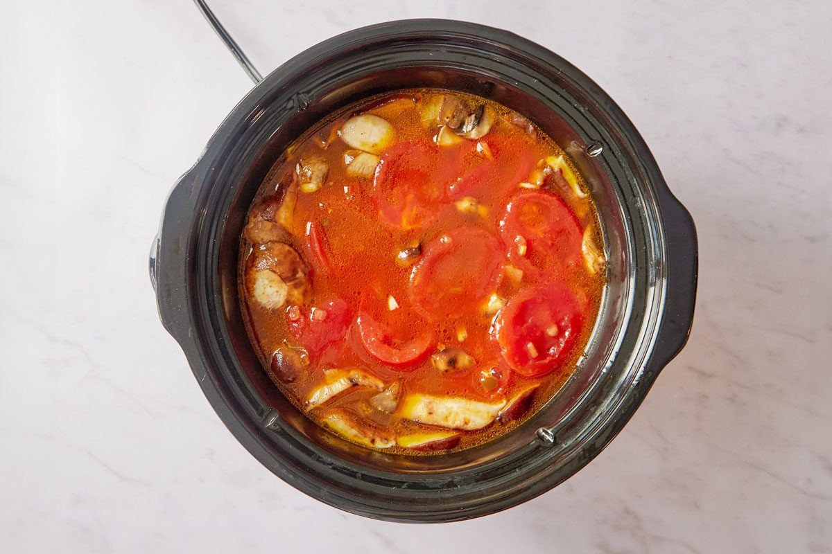 broth and tomatoes in a slow cooker