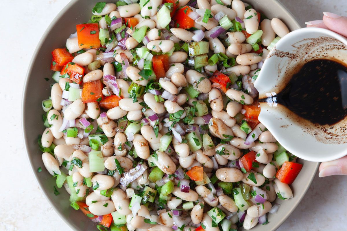 Step 3 of Taste of Home White Bean Salad is to add the dressing to the salad and toss before refrigerating an hour