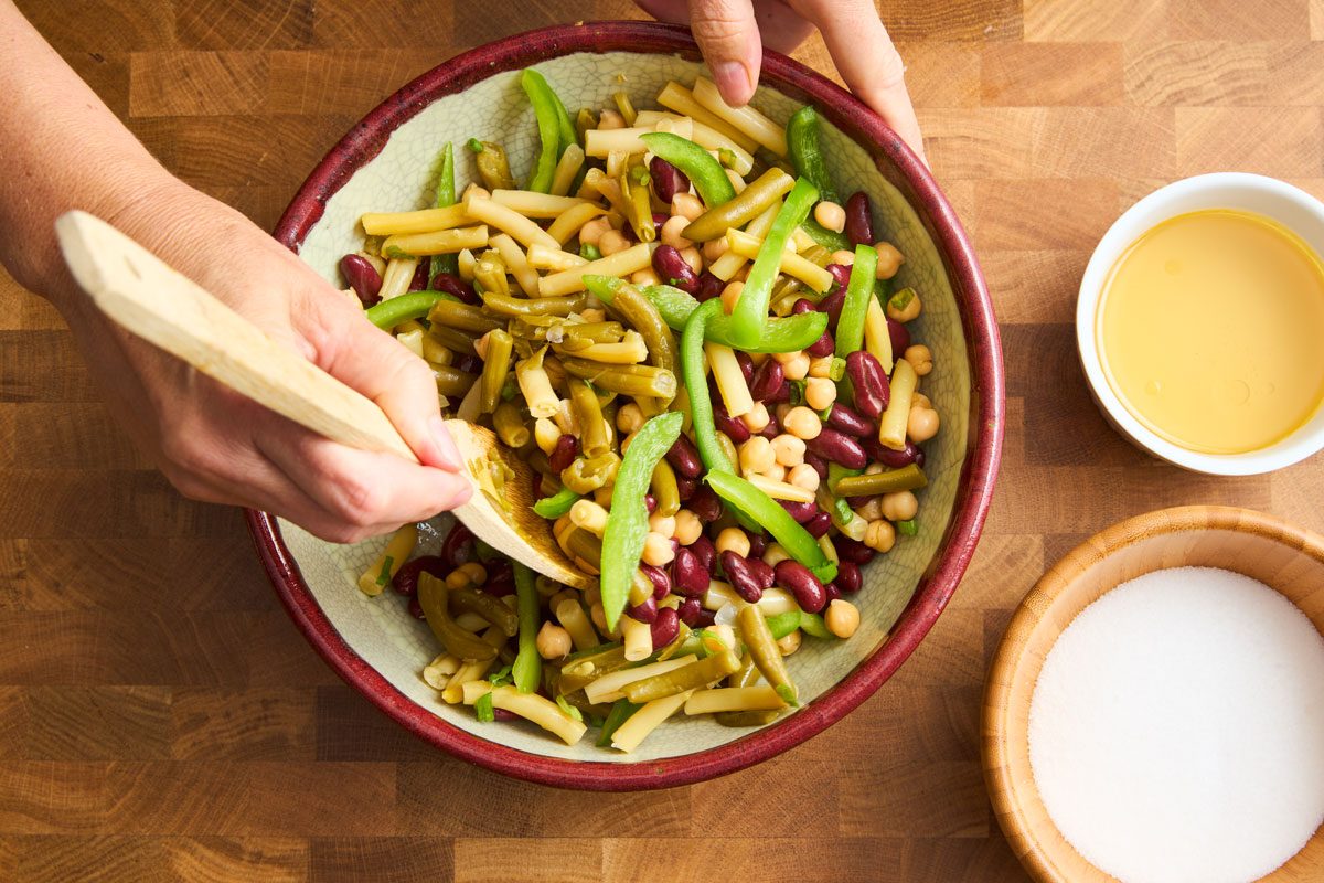 close up of combining beans with vegetables in bowl