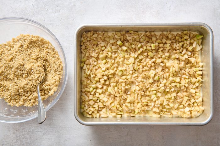 Topping the cheesecake with apple and streusel