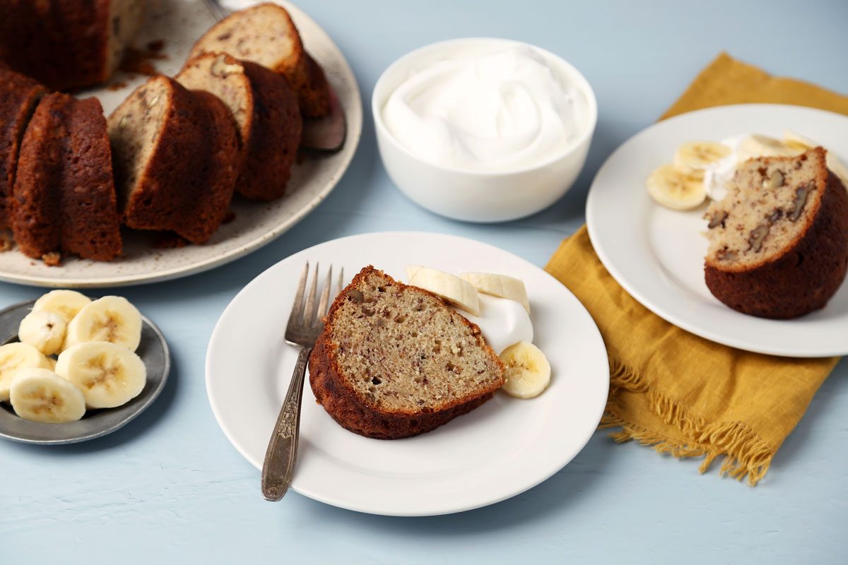 Taste of Home's Banana Bundt Cake sliced and served on a plate on a blue surface.