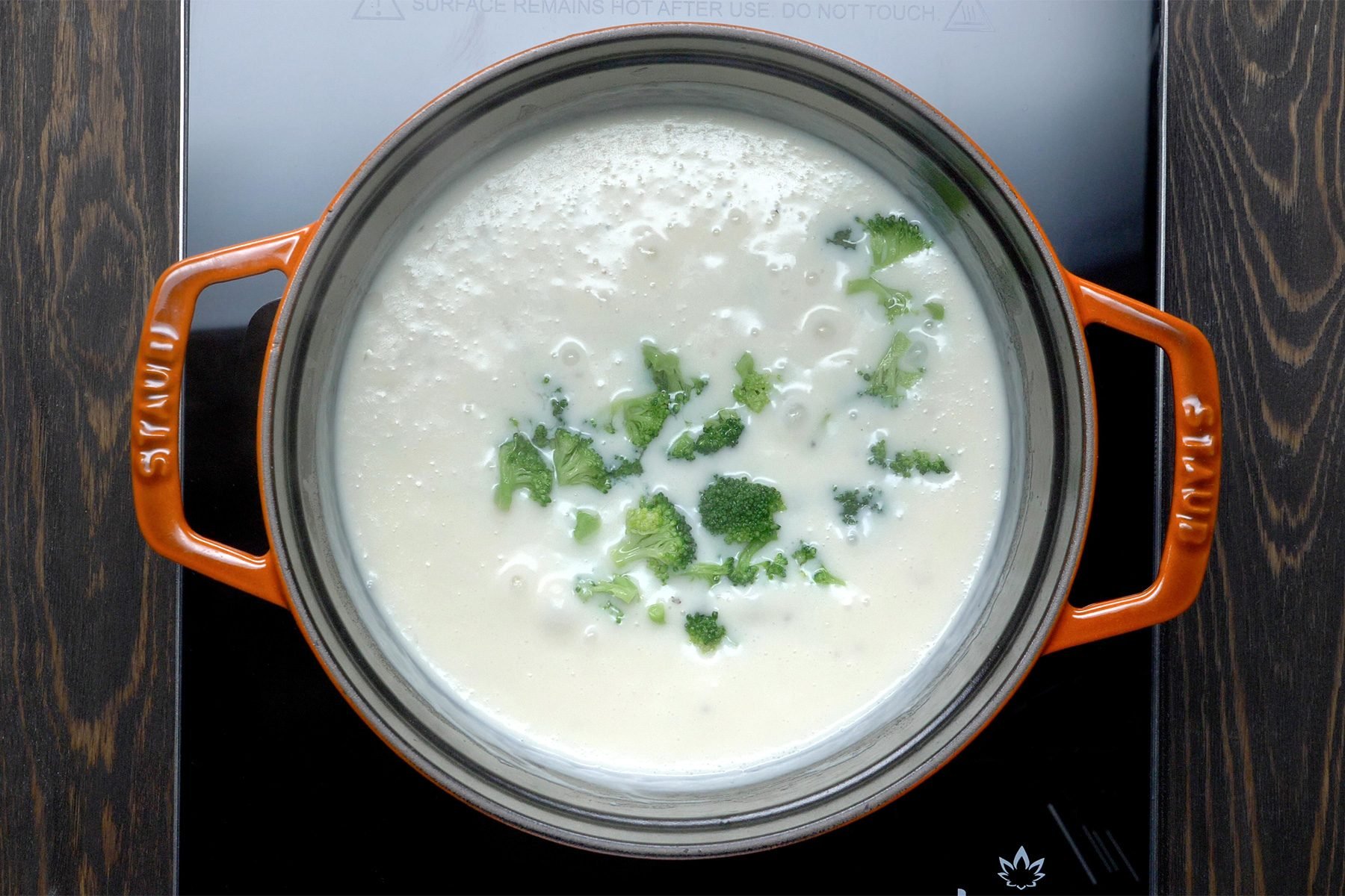 overhead shot; wooden background; boiling the mixture in a small saucepan;