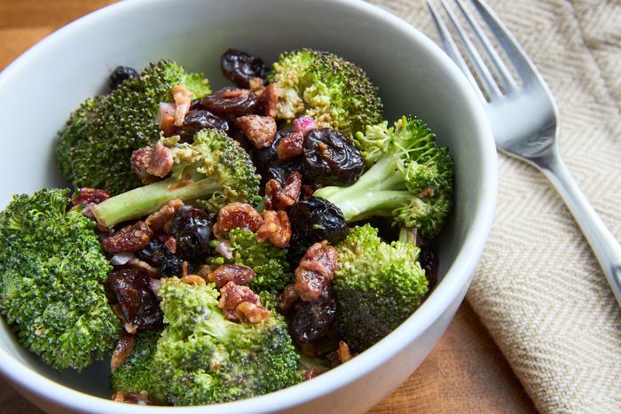 Bacon and broccoli salad served in bowl with fork and napkin