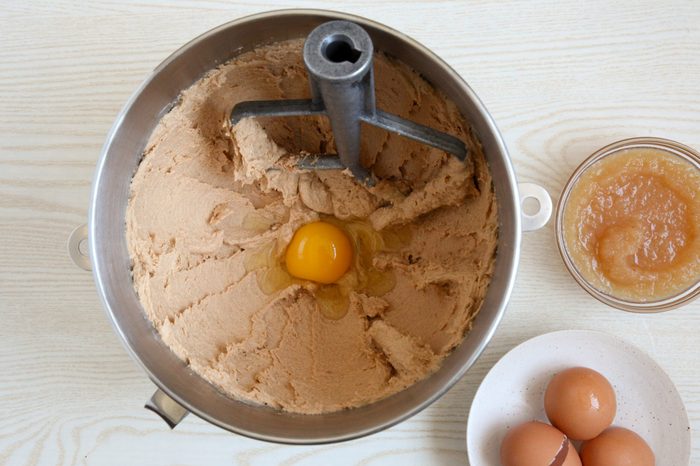 Adding eggs and applesauce to cookie dough