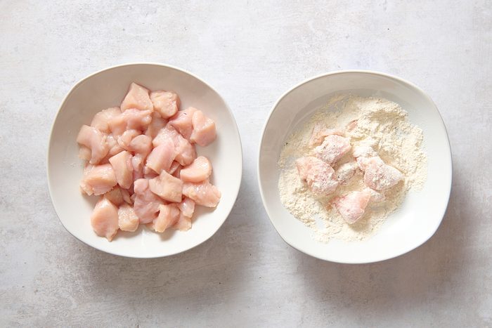 Dredging chicken pieces in the flour mixture