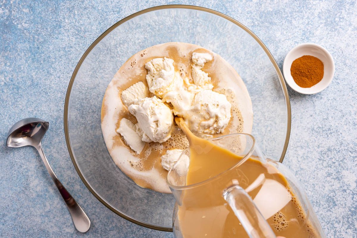 Taste of Home coffee punch recipe photo of mixing ingredients into punch bowl filled with vanilla ice cream.