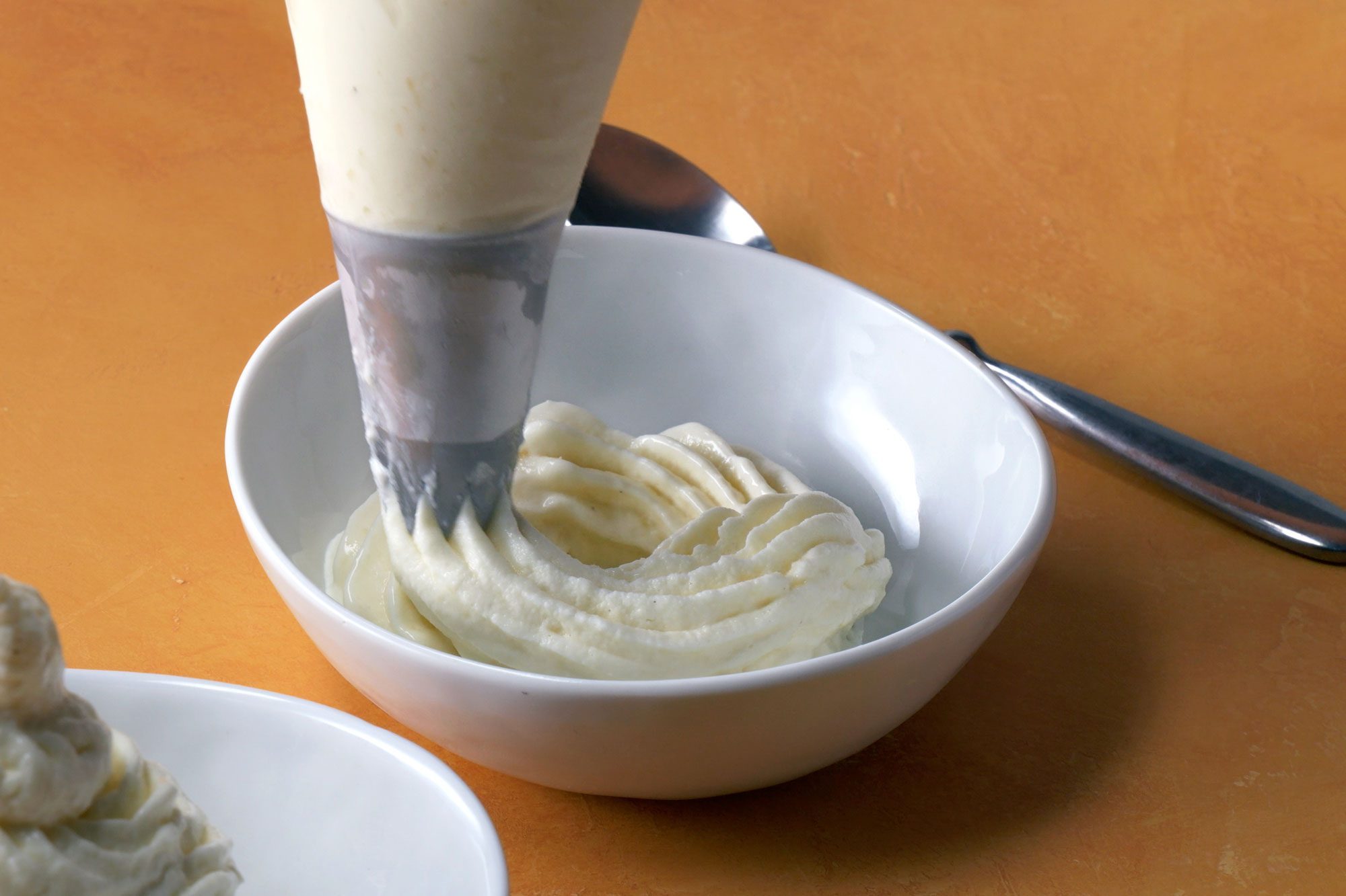 Pipe in two bowls topping each with swirl spoon