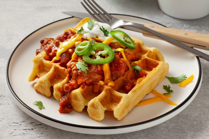 Eye level shot of cornbread waffle on plate with garnish
