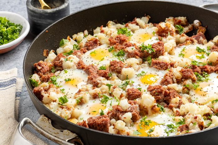 Taste of Home Corned Beef Hash and Eggs recipe photo of the finished recipe in a skillet.