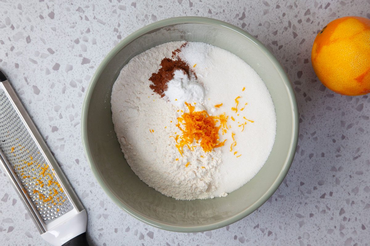 Step 1 of Taste of Home Cranberry Muffins is to combine the flour, sugar, baking powder, nutmeg, cinnamon, baking soda, ginger, salt and orange zest