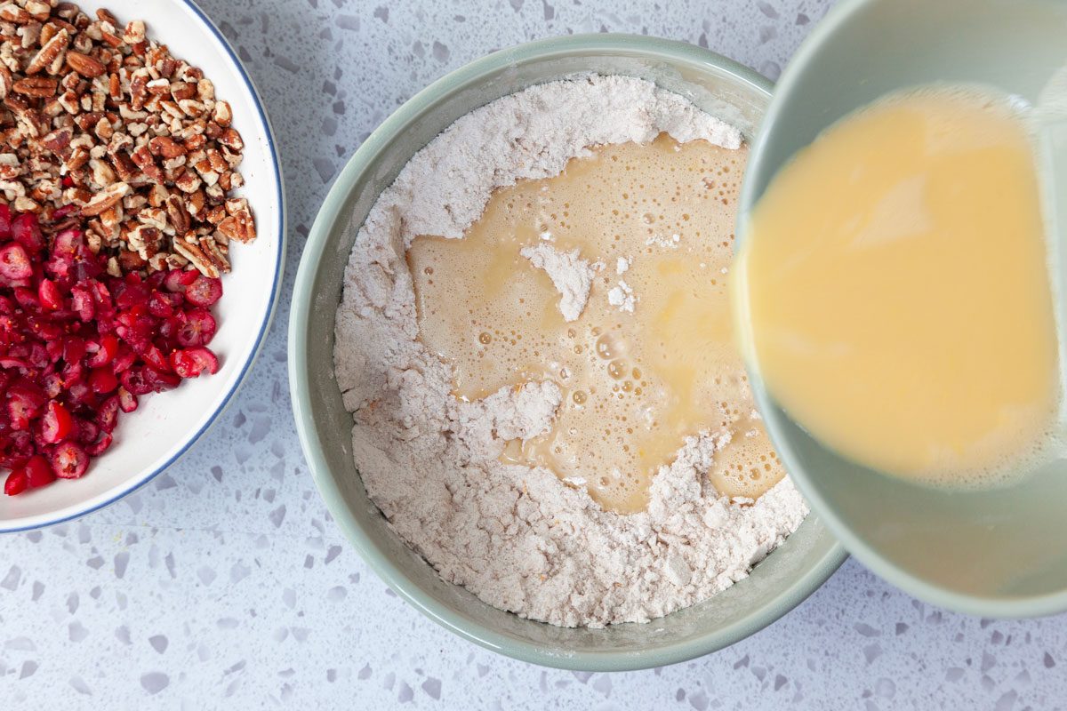 Step 3 of Taste of Home Cranberry Muffins is to combine the orange juice, lightly beaten eggs and vanilla extract. Whisk until well blended. Gradually pour the wet ingredients in to the dry ingredients, then stir until the mixture is just moistened.