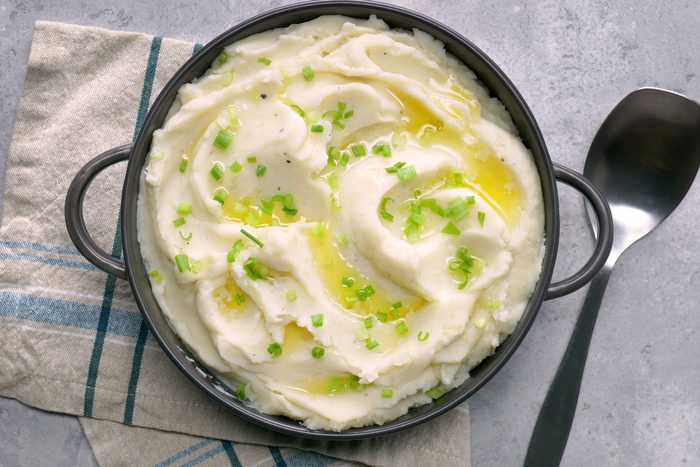 Creamy Mashed Potatoes in a stockpot sprinkled with green onion on top