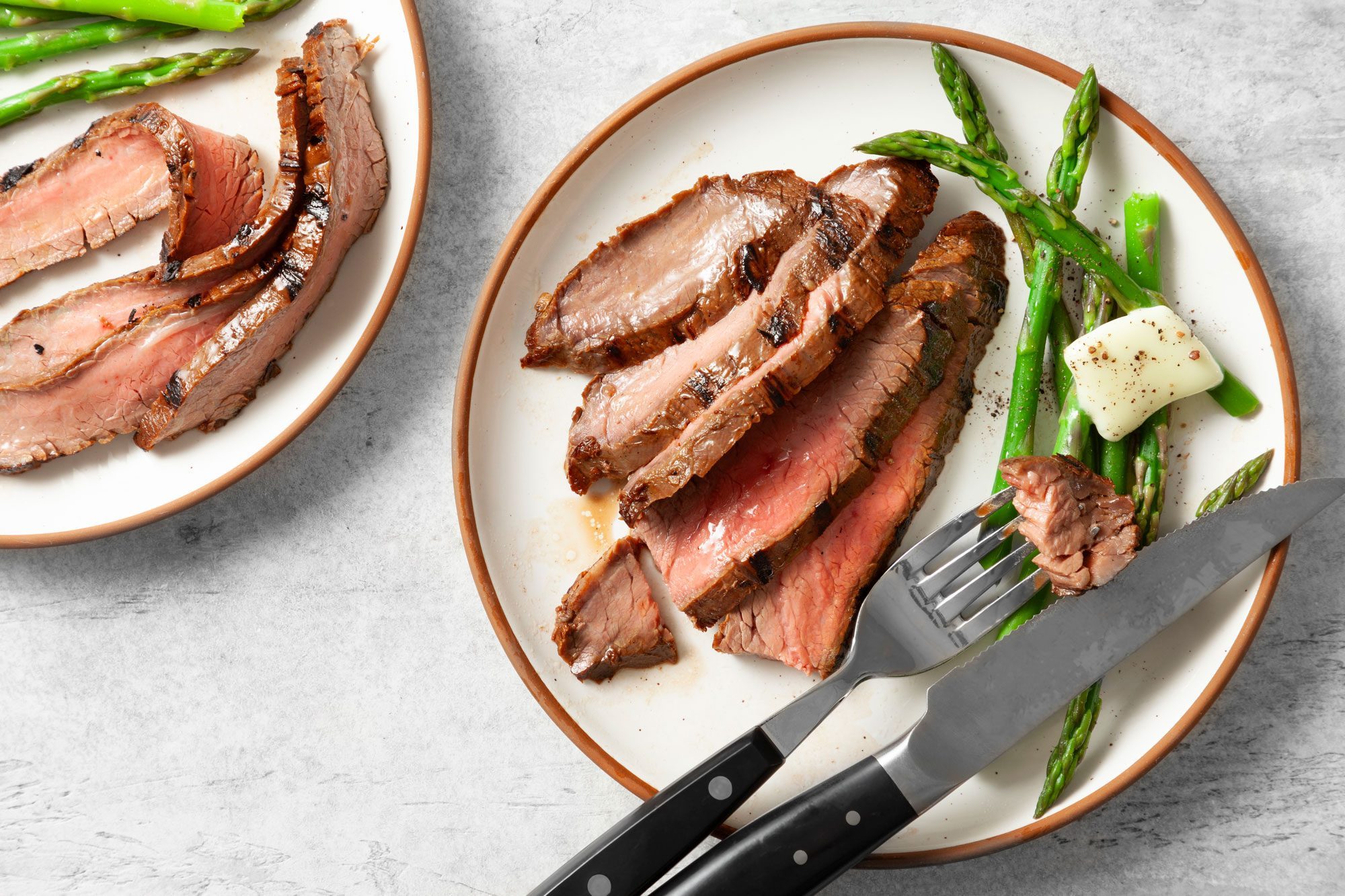Grilled Flank Steak served in two plates with beans