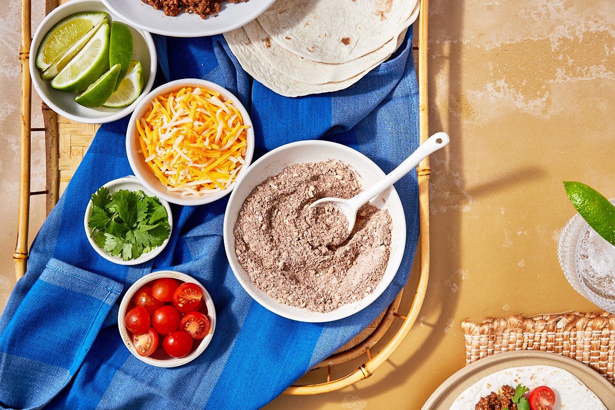 Homemade Taco Seasoning Hero- seasoning in a bowl with taco toppings surrounding