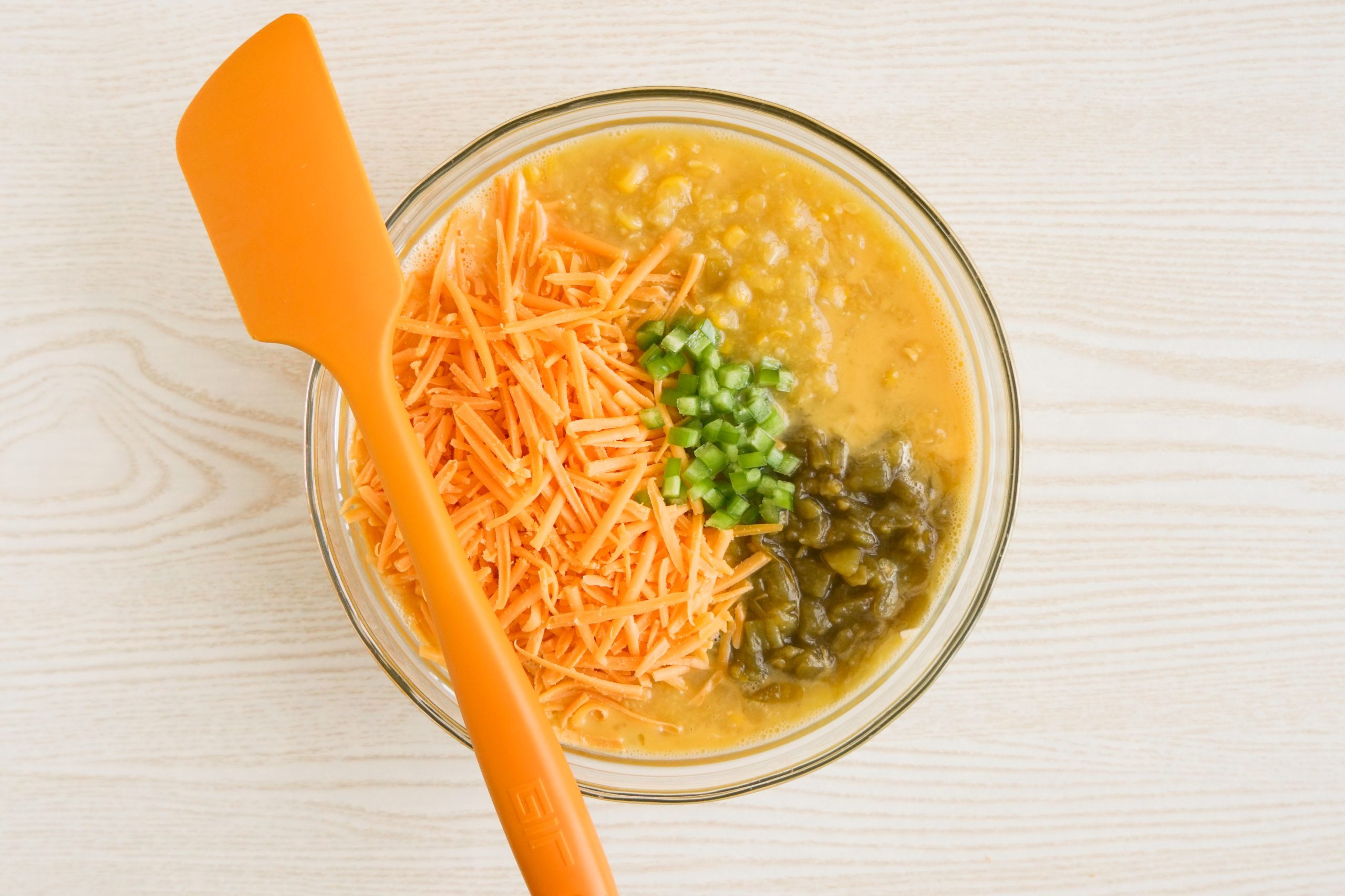 Mixing cheesy Mexican cornbread batter