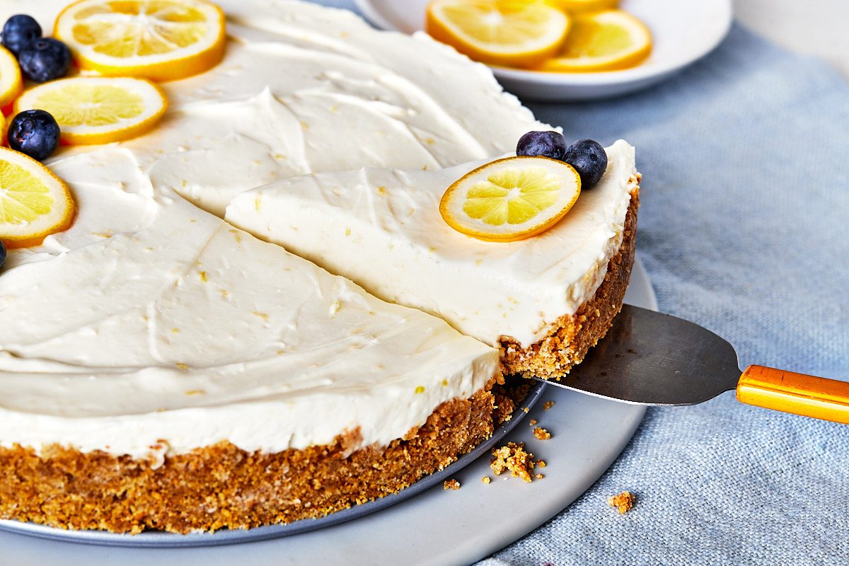 No Bake Lemon Cheesecake Hero- removing one slice with cake server