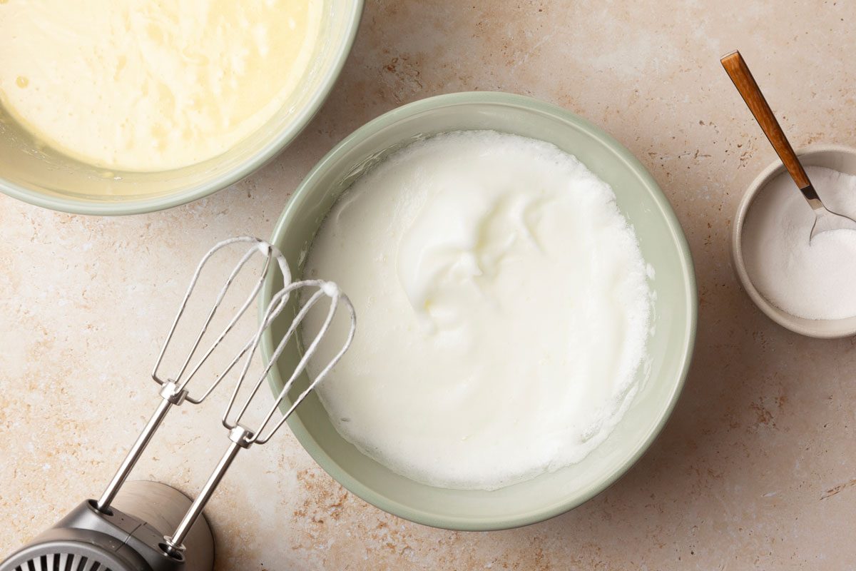 Step 3 of Taste of Home Pineapple Coconut Cake is to beat the egg whites on medium speed until soft peaks form. Gradually add the remaining sugar, 1 tablespoon at a time, beating on high until stiff peaks form. Fold the beaten egg whites into the cake batter.