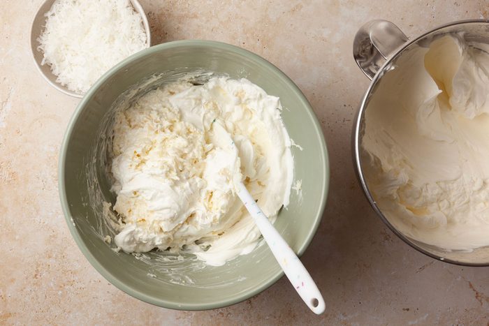 Step 5 of Taste of Home Pineapple Coconut Cake is to beat the whipping cream until it thickens. Add 1 cup of confectioners' sugar and continue beating until stiff peaks form. In another bowl, beat the cream cheese, crushed pineapple and remaining confectioners' sugar until blended. Stir in 2 cups of shredded coconut. Fold the whipped cream into the mixture.