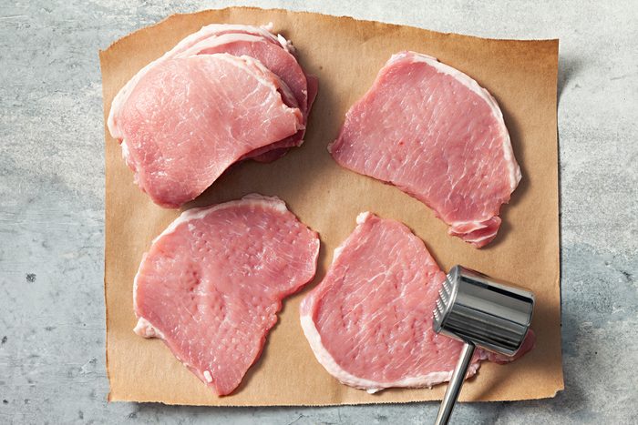 top view of pounding pork with meat mallet
