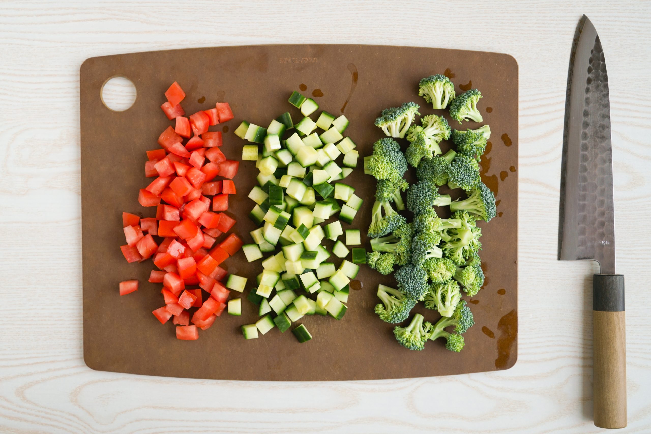 Chopping tomatoes, cucumber, and broccoli