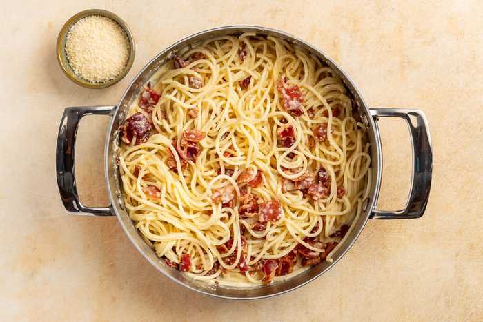 Taste of Home Skillet Pasta with Bacon and Egg recipe photo of combining the sauce and the pasta together in the skillet.