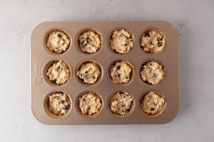 Soft Blueberry Oatmeal Muffins batter in a lined muffin tin.
