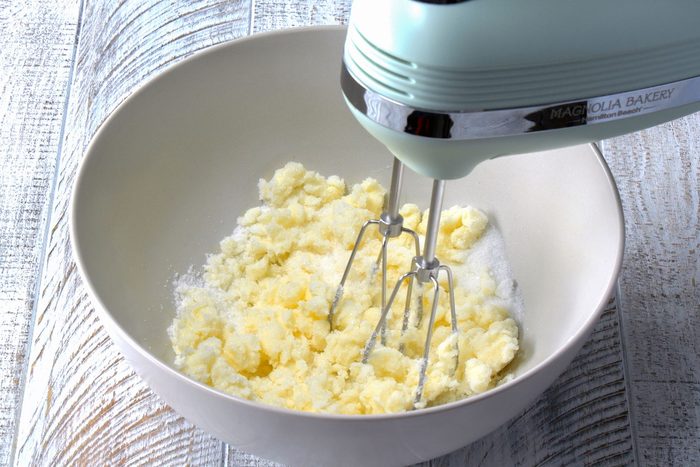 A stand mixer can be seen mixing butter and sugar in a bowl.