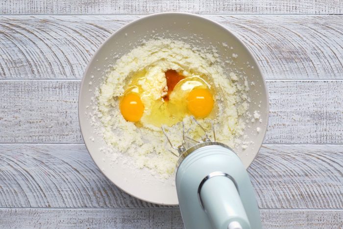 Eggs and vanilla extract are being mixed in a bowl.