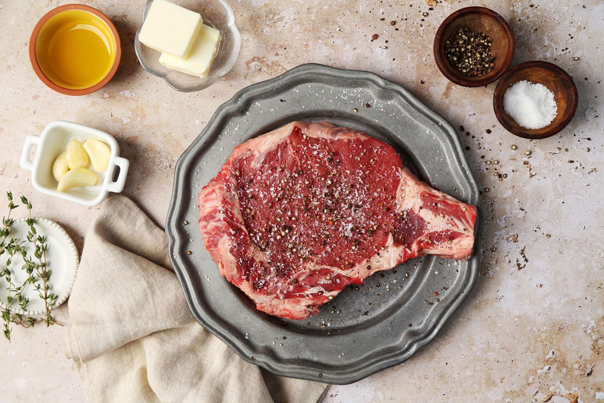 A how to look into Taste of Home's homemade Steak Frites. Steak on a plate seasoned with salt and black pepper.