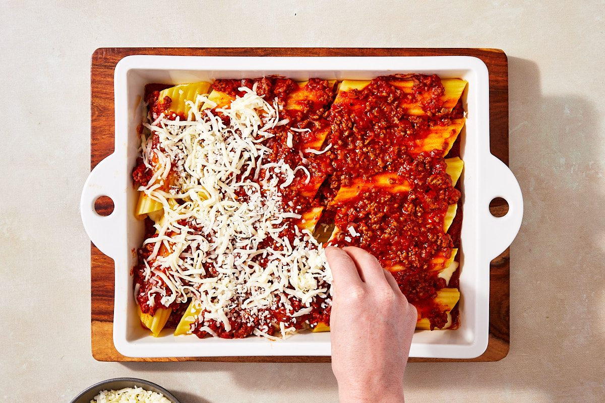 String Cheese Manicotti Step 6- Sprinkling baked manicotti with cheese before baking again