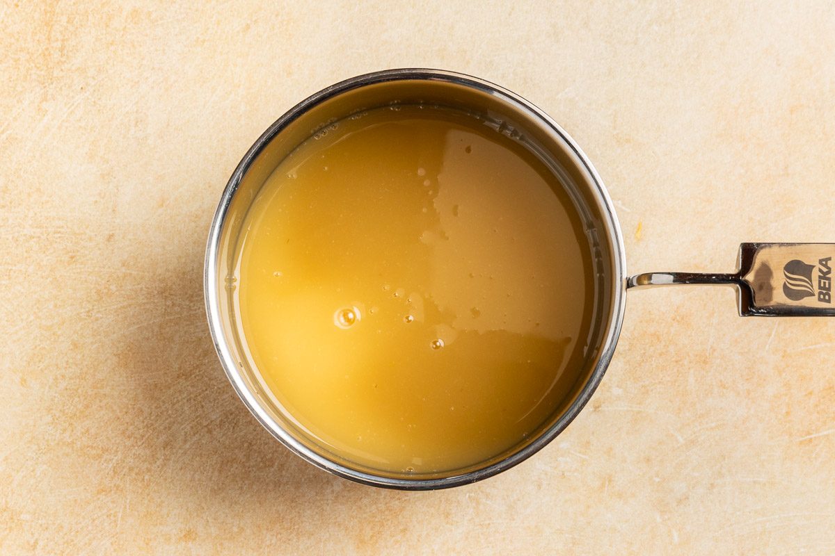 Taste of Home Taffy Apple Salad recipe photo of the reserved pineapple juice, egg, sugars, flour and vinegar cooked in a saucepan.