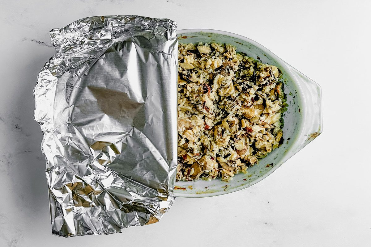 Taste of Home wild rice casserole in a pyrex dish covered with foil on a marble surface.