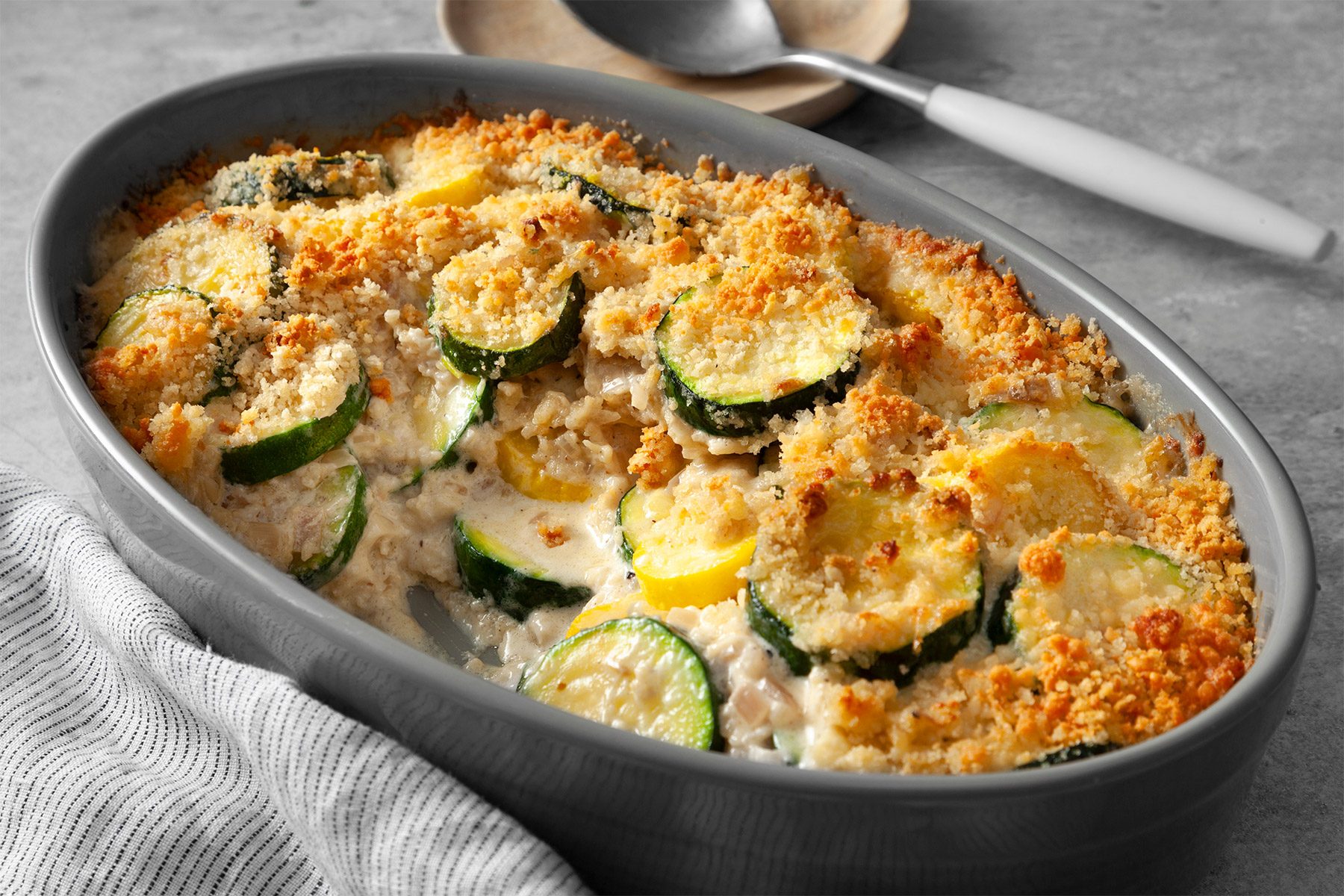 close shot of yellow squash and zuchhine gratin in a large dish