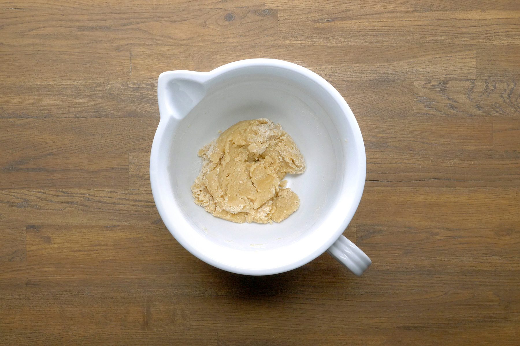 overhead shot; wooden background; combined all-purpose flour, sugar, baking powder, baking soda, salt, ground cinnamon in a white bowl;