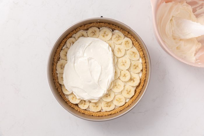 Banana cream cheesecake layers being assembled.