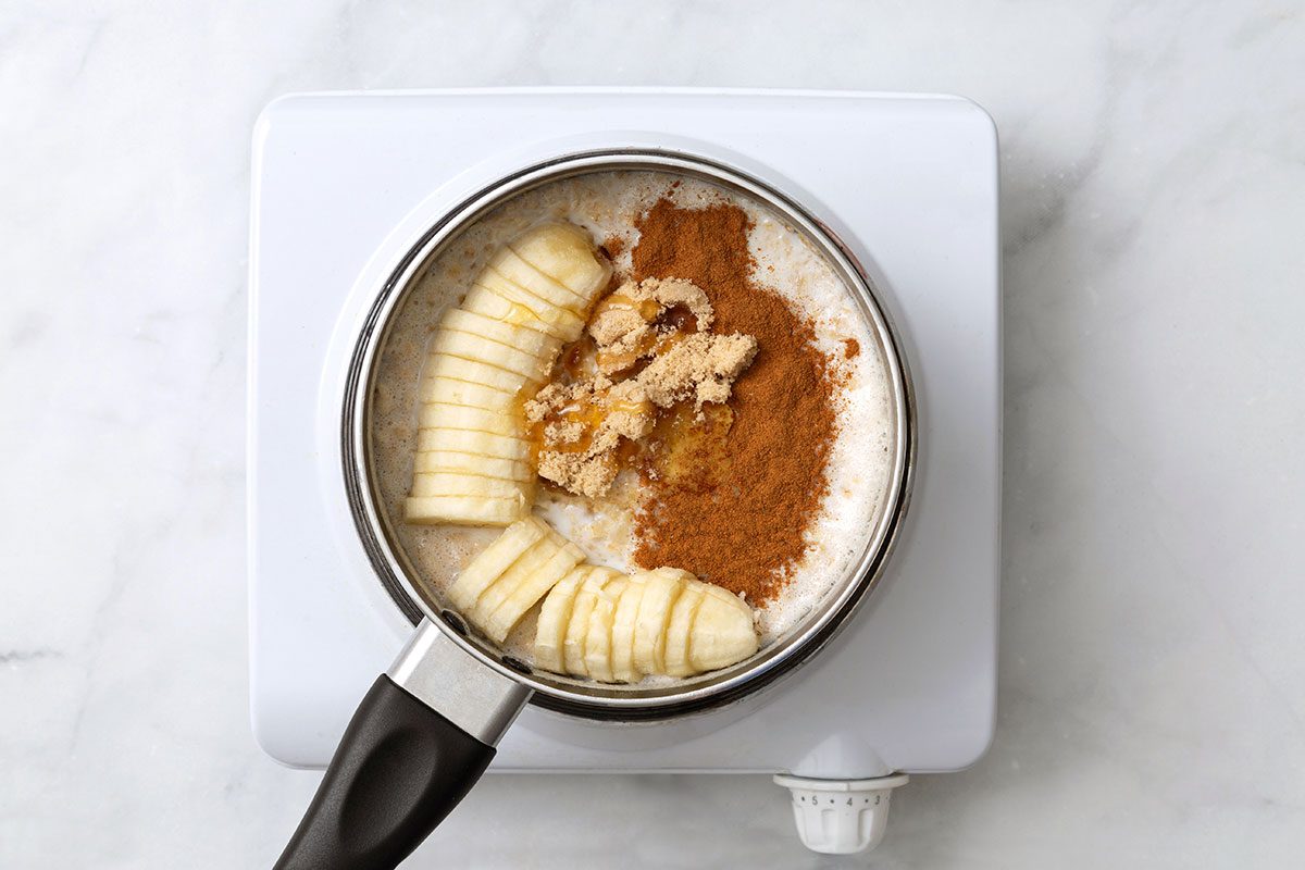 Sliced banana, brown sugar, honey and ground cinnamon mixed with cooked quick oats and milk in a small sauce pan
