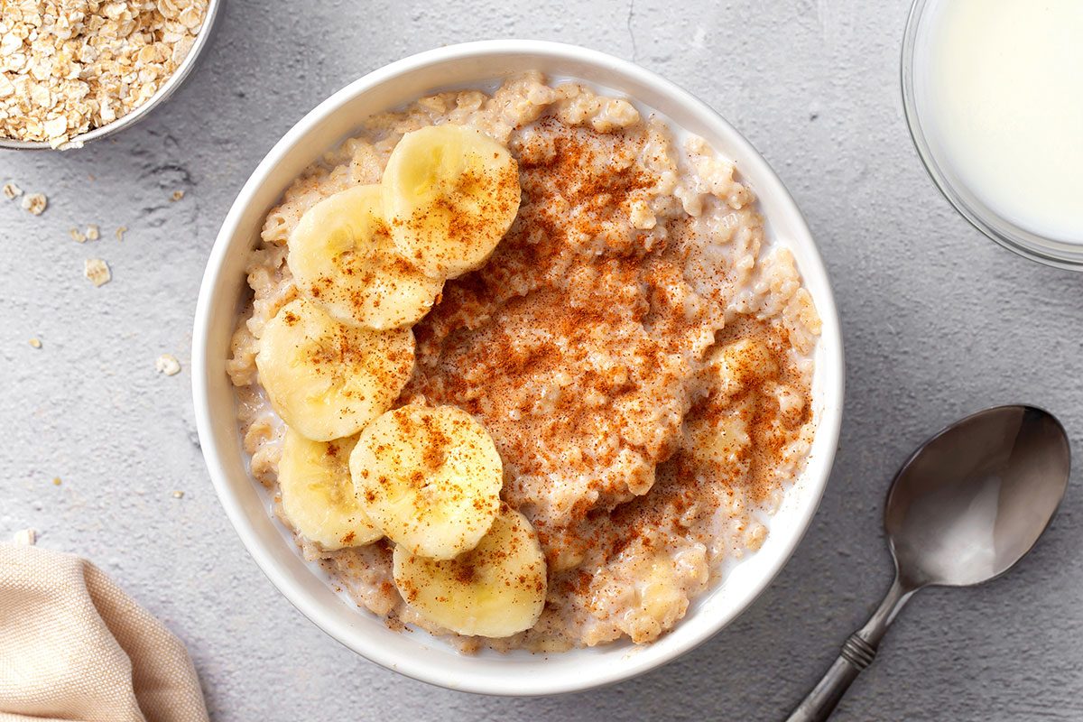 Overhead shot of banana oatmeal topped with sliced banana and cinnamon in a bowl