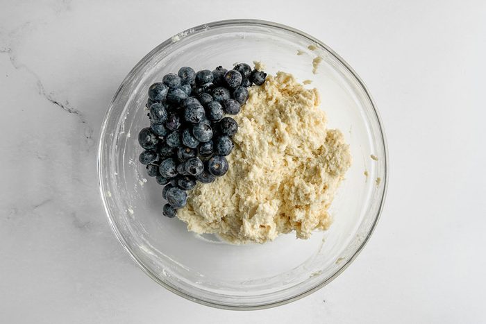 Batter for Taste of Home Blueberry Biscuits in a glass bowl on a marble surface