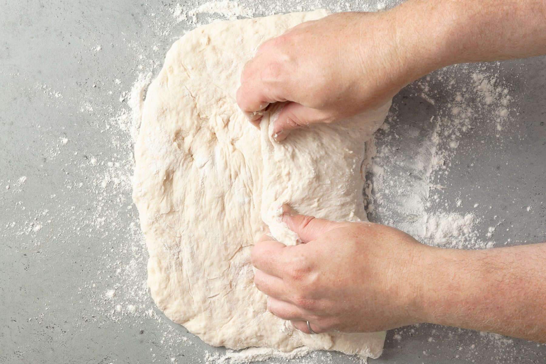 over view shot of kneading dough with hands 