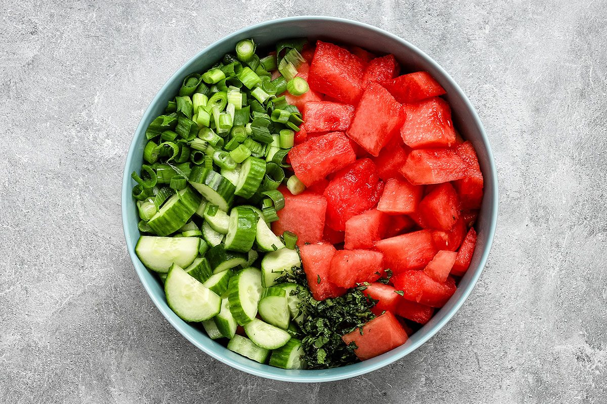 Cucumber watermelon salad in a large bowl, ready to toss with dressing.