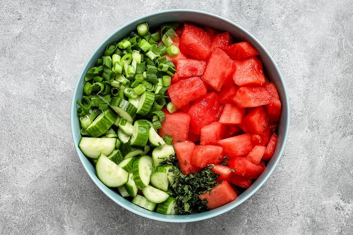 Cucumber watermelon salad in a large bowl, ready to toss with dressing.