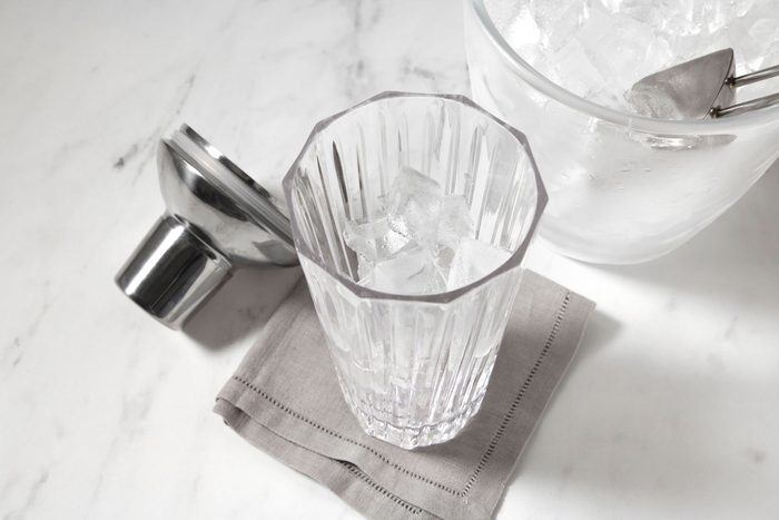 A clear glass tumbler filled with ice cubes