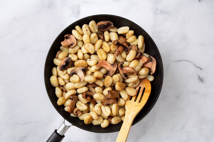 Cooked mushrooms and gnocchi with melted better in a large skillet for Gnocchi Alfredo recipe for Taste of Home