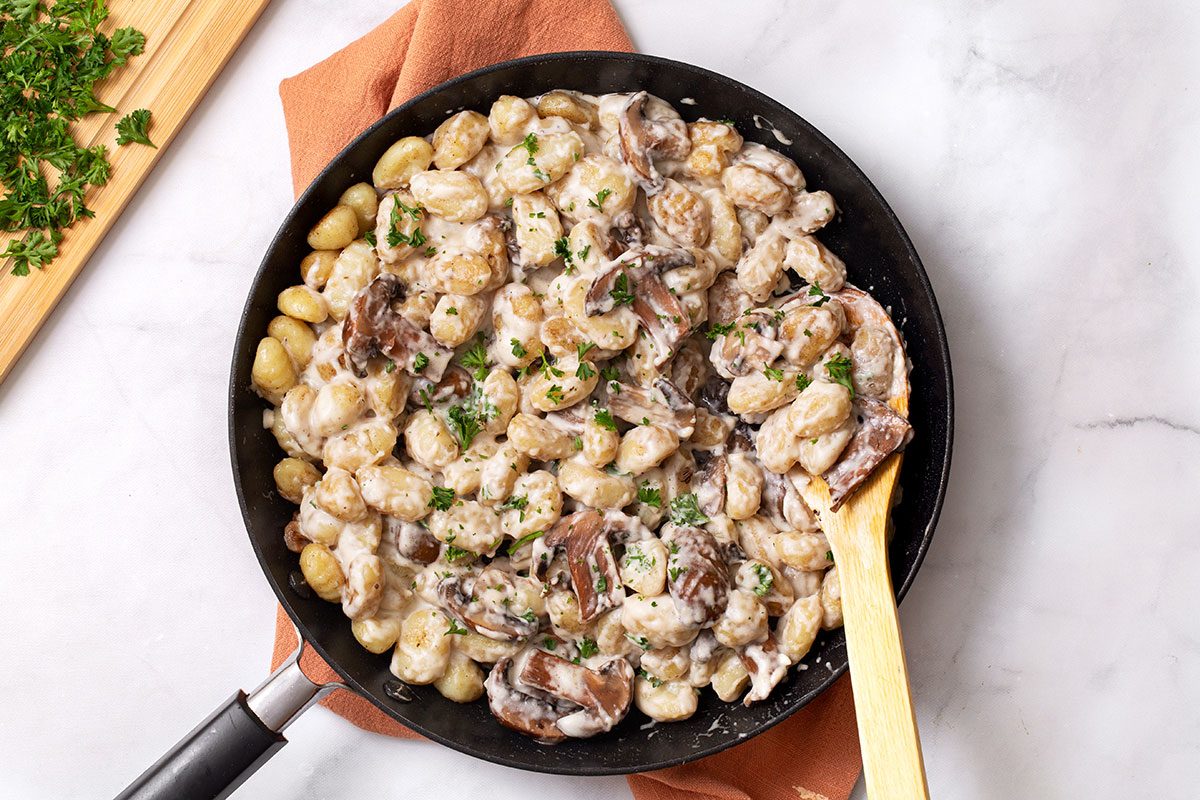 Cooked gnocchi and mushrooms mixed with cream sauce for Gnocchi Alfredo for Taste of Home