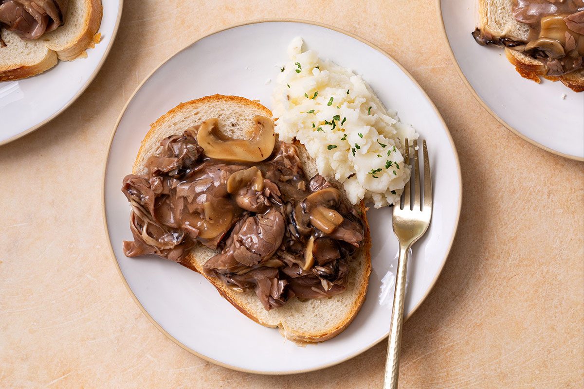 Hot Roast Beef Sandwich on a plate with a side of mashed potatoes for Taste of Home